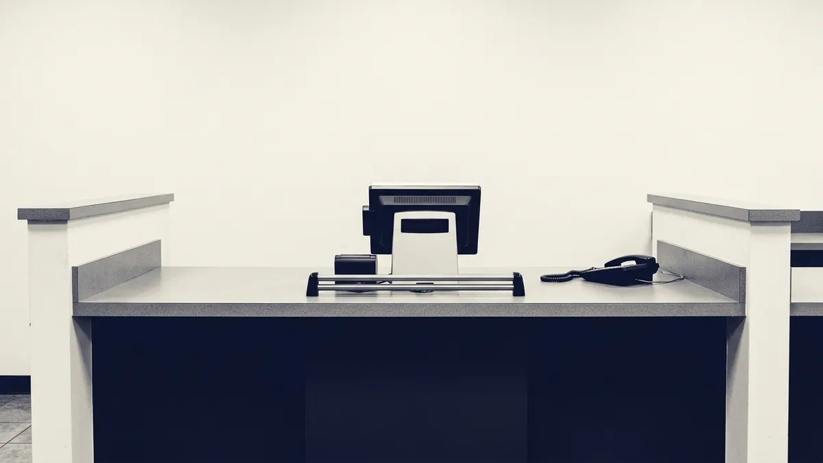 An empty franchise back office with certificates, paperwork and a phone off the hook