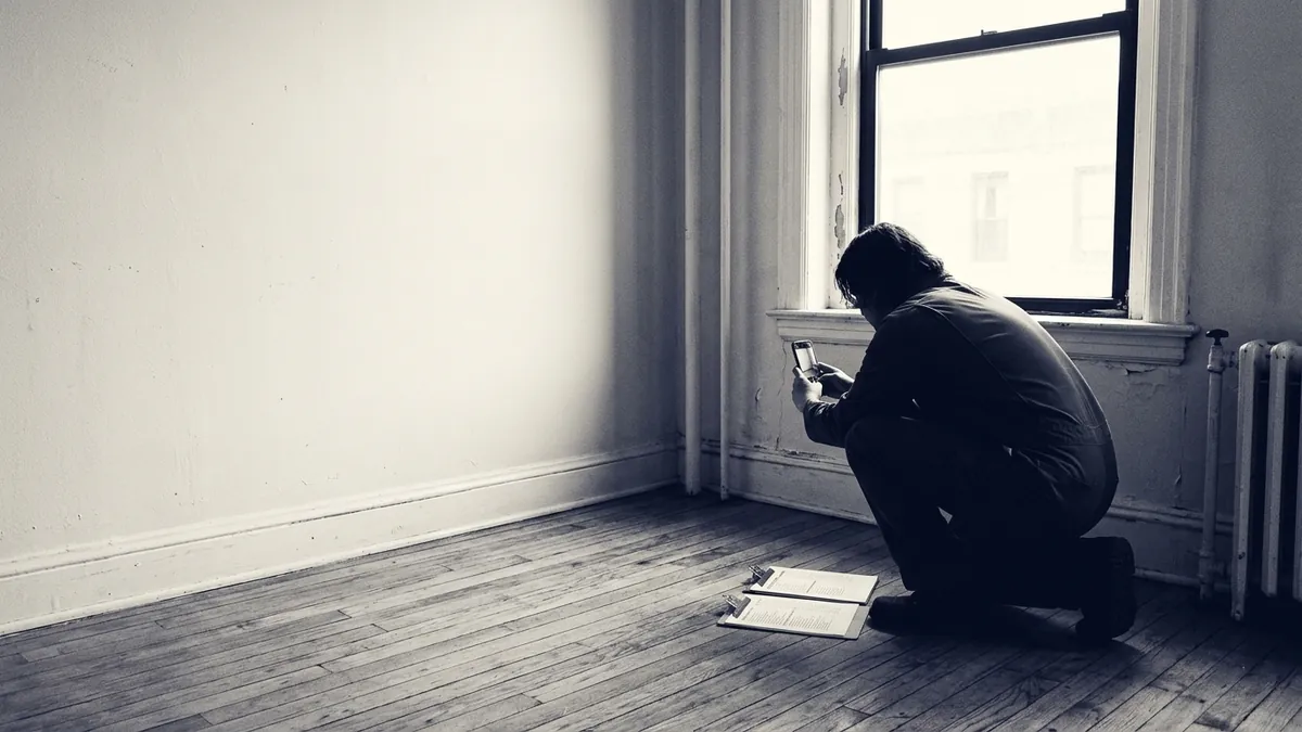 A property manager triaging maintenance requests at a desk with contractor paperwork
